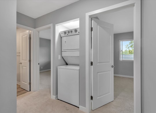 a laundry room with a washer and dryer and a door to a closet