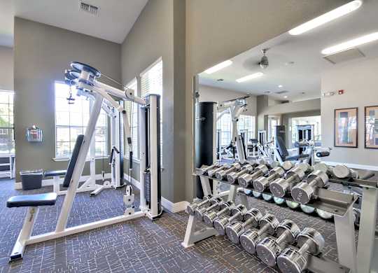 Fitness center with free weights and equipment at Rosemeade Apartments, California