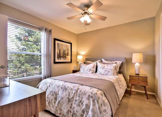 Bedroom with ceiling fan and neutral decor at Rosemeade Apartments, Roseville