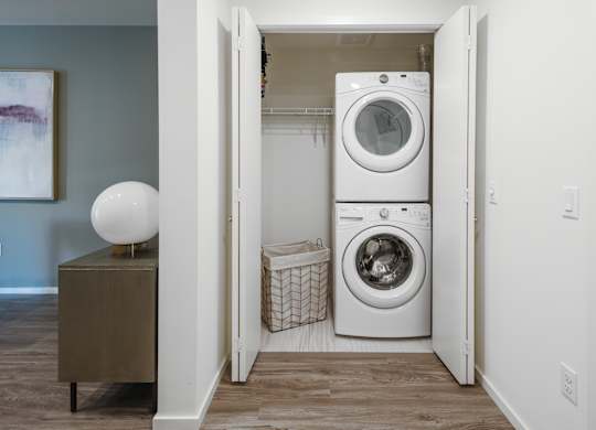 A laundry room with a washer and dryer stacked on top of each other.