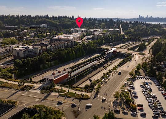 A red pin marks a location on a map of a city with a highway and buildings.