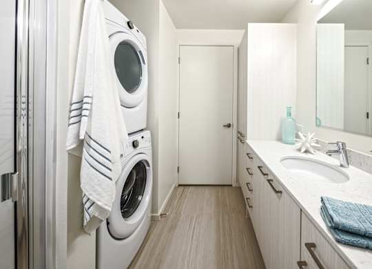 A white washing machine is in a small laundry room.