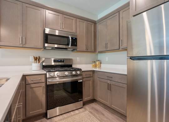 A kitchen with a stove, microwave, and refrigerator at Ventura Townhouses, West Olive  , 49460