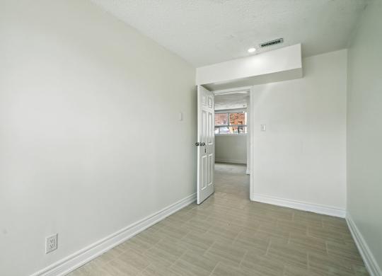 A white room with a doorway leading to another room.
