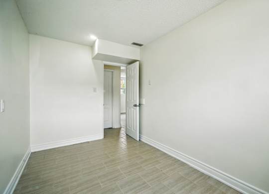 A room with a white door and a light on the wall.