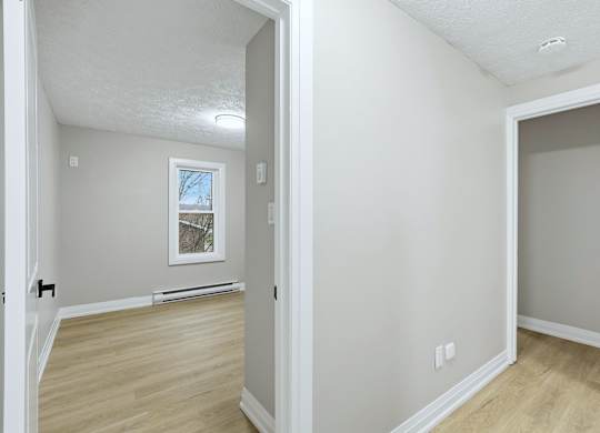 A room with a window and a picture on the wall.