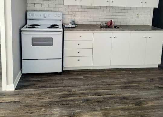 A white kitchen with a stove and cabinets.