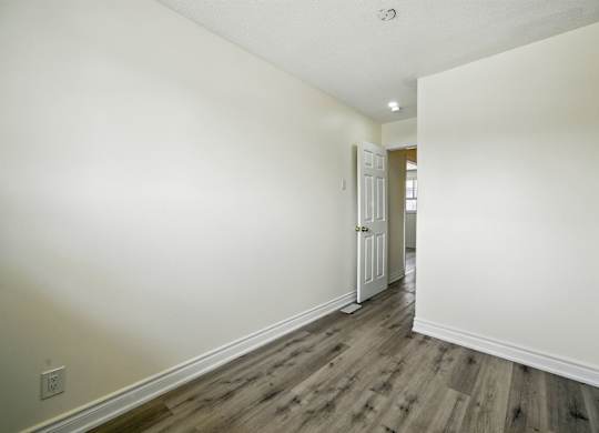 A room with a wooden floor and white walls.