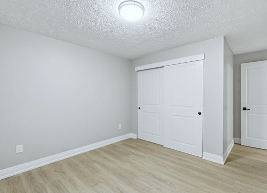 A white room with a sliding door and a wooden floor.