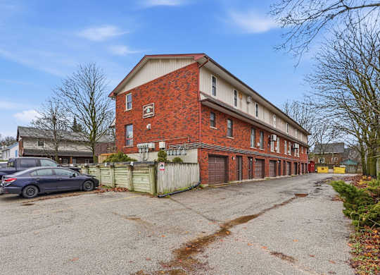 A red brick building with a car parked in front.