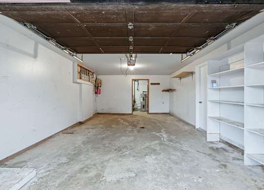 A room with a white wall and a door in the middle.