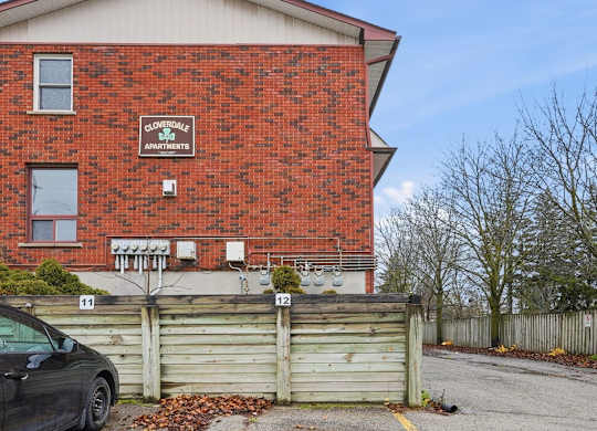 A red brick building with a black car parked in front of it.