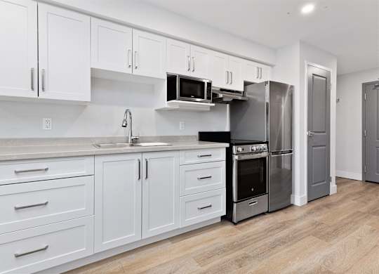 A kitchen with white cabinets and stainless steel appliances.