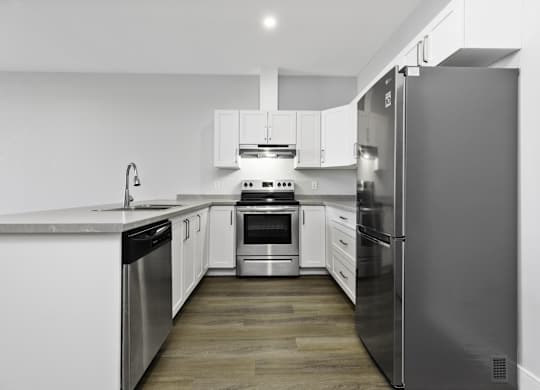 A modern kitchen with stainless steel appliances and white cabinetry.