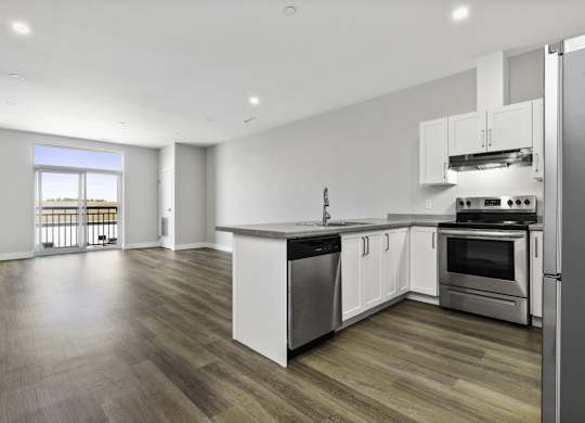 A modern kitchen with white cabinets and stainless steel appliances.