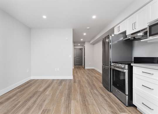 A kitchen with a refrigerator, oven, and microwave.