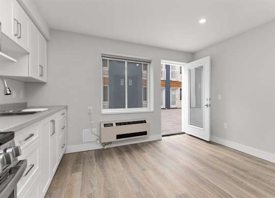 A kitchen with white cabinets and a window.