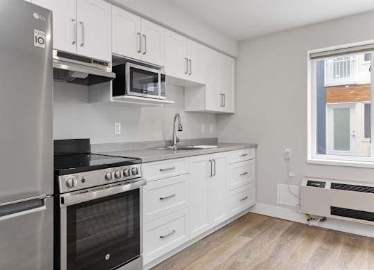 A kitchen with white cabinets and stainless steel appliances.