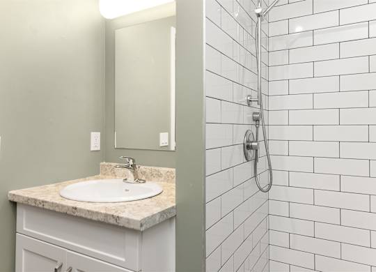 A white sink with a marble counter top in a bathroom.
