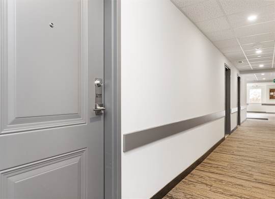 A white door with a silver handle and a sign above it that says