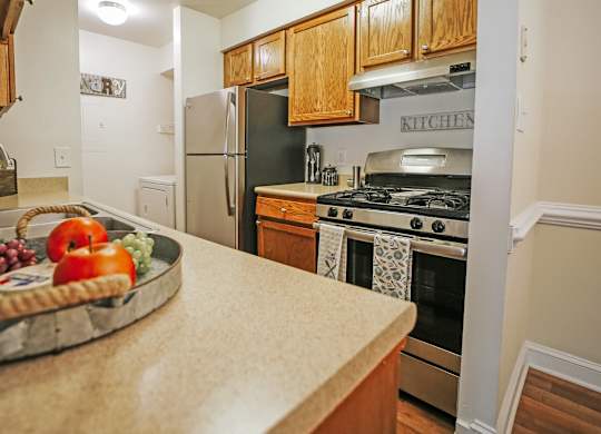 A kitchen with a black refrigerator and a wooden counter.