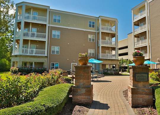 A sunny day at the entrance of a well-maintained apartment complex.