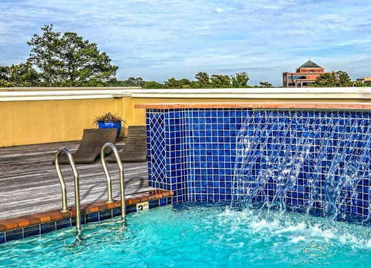 A blue tiled pool with a waterfall feature.