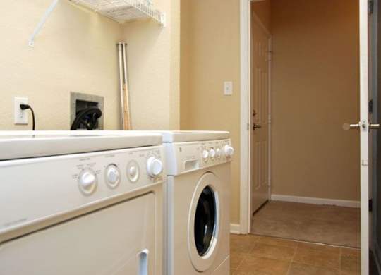 A white washing machine and dryer in a laundry room.