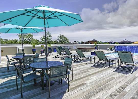 A patio with a table and chairs and a blue umbrella.