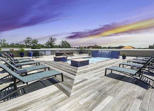 A wooden deck with lounge chairs and a pool.