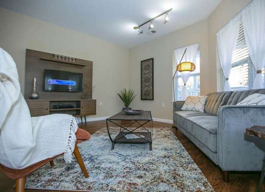 A living room with a couch, chair, and television.