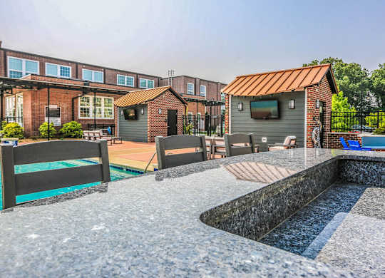 A backyard with a pool and a small building.