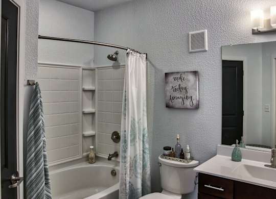 A bathroom with a white tub, toilet, and sink.