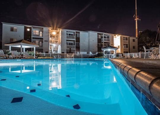 A swimming pool at night with lights reflecting on the water.