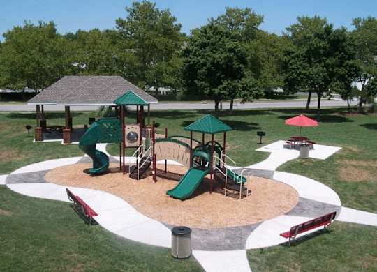A playground with a green slide and a red slide.