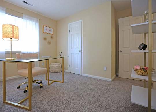 A room with a glass table and a chair.