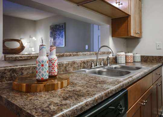 A kitchen with a sink, a cutting board, and a countertop.