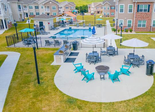 An aerial view of a pool surrounded by chairs and umbrellas.