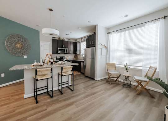 A kitchen with a table and chairs by the window.