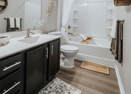 A bathroom with a white toilet, a sink, and a bathtub.