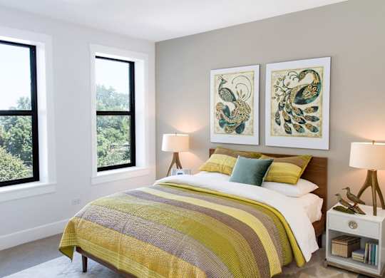 A bedroom with a large bed and two lamps.