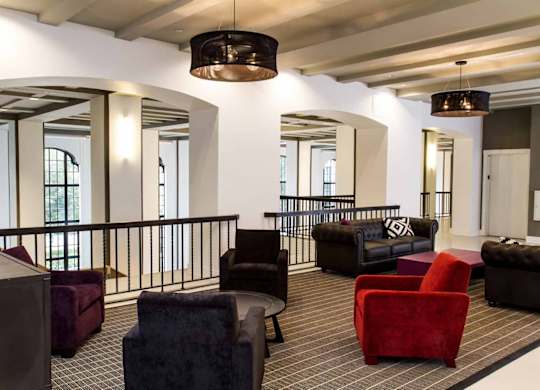 A large room with a balcony and a variety of seating options.