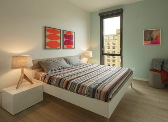 A bedroom with a bed, nightstand, and two lamps.
