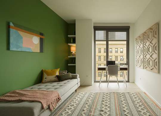 A bedroom with a bed and a chair in front of a window.
