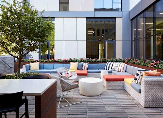A modern outdoor seating area with a variety of colorful cushions and chairs.