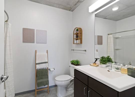 A bathroom with a toilet, sink, and mirror.