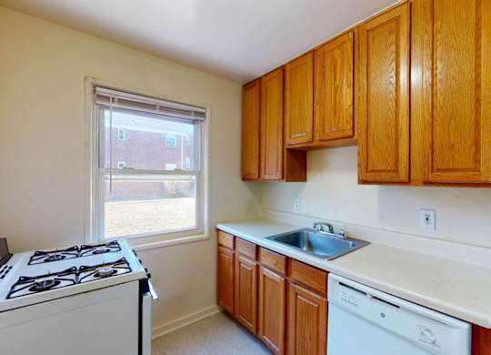 A kitchen with wooden cabinets and white appliances.