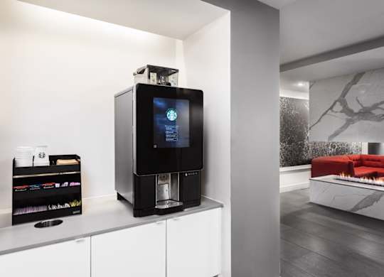 A modern kitchen with a black coffee machine on the counter.
