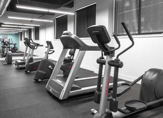 A gym with treadmills and elliptical machines.