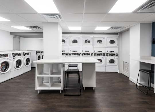 A laundry room with washing machines and a counter.